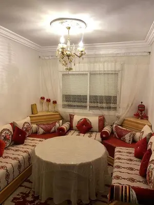 a living room with couches and a table and a chandelier at Joude in Fès