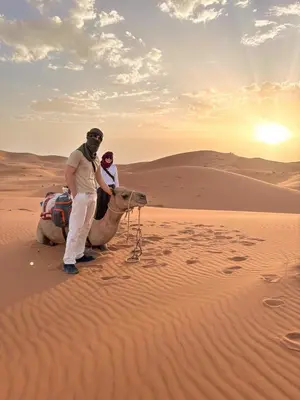 two people on a camel in the desert at dreaming desert Luxury Camp in Hassilabied