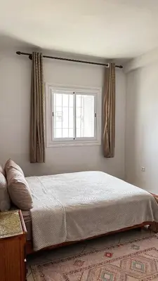 a bedroom with a large bed and a window at Appartement spacieux à Agadir in Oulad Akkou