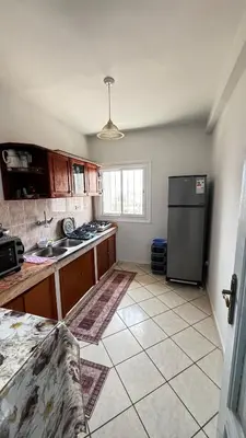 a kitchen with a refrigerator and a tile floor at Appartement spacieux à Agadir in Oulad Akkou