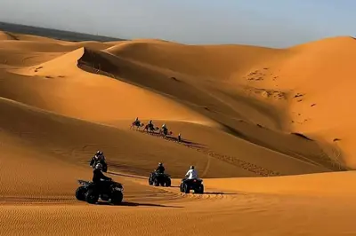 a group of people riding motorcycles in the desert at luxury desert night camp in Merzouga