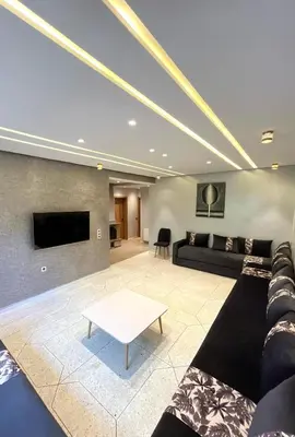 a living room with a couch and a tv at Appartement Al Arz Atlas in Ifrane