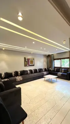 a large living room with a couch and a table at Appartement Al Arz Atlas in Ifrane
