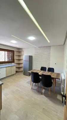 an office with a table and chairs and a kitchen at Appartement Al Arz Atlas in Ifrane