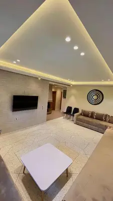 a living room with a couch and a tv at Appartement Al Arz Atlas in Ifrane