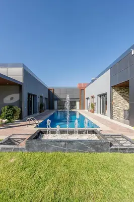 a swimming pool with a fountain in front of a building at Villa Ramona, Calme, Luxe et Piscine in Marrakech