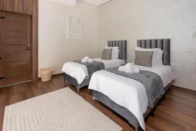 a bedroom with two beds and a rug at Villa Ramona, Calme, Luxe et Piscine in Marrakech