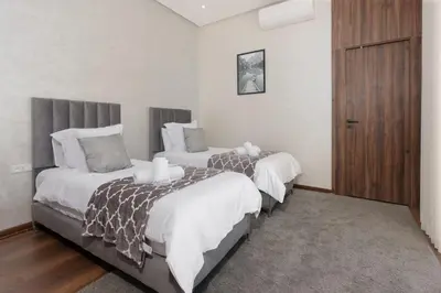 a bedroom with two beds and a wooden cabinet at Villa Ramona, Calme, Luxe et Piscine in Marrakech