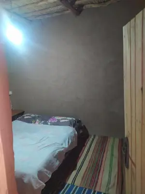 a small bedroom with a bed in a room at Dar Bafdil in Kasr Bounou