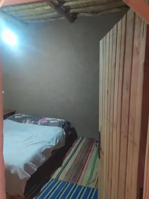 a bedroom with a bed and a wooden wall at Dar Bafdil in Kasr Bounou