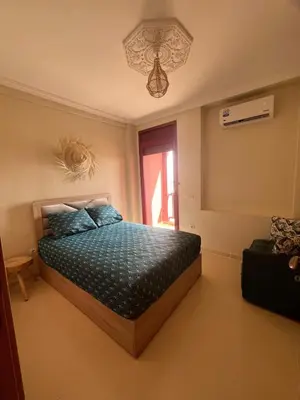 a bedroom with a bed with blue pillows and a window at Appartement de 3 chambres pour 6 voyageurs à 20 minutes de centre ville de Marrakech in Azib Oulad Lâdem