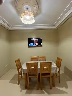 a dining room with a table and chairs and a tv at Appartement de 3 chambres pour 6 voyageurs à 20 minutes de centre ville de Marrakech in Azib Oulad Lâdem
