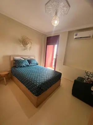 a bedroom with a bed with blue pillows and a window at Appartement de 3 chambres pour 6 voyageurs à 20 minutes de centre ville de Marrakech in Azib Oulad Lâdem
