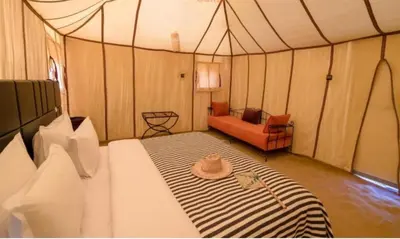 a tent room with a bed with a hat on it at Sand Fish Camp in Merzouga