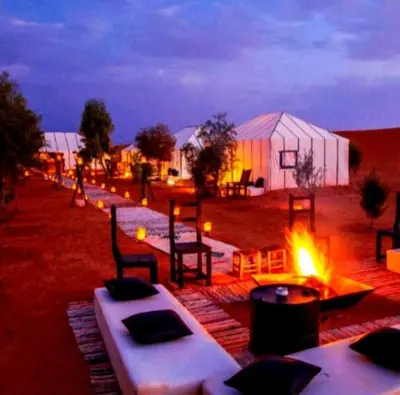 a group of tables and chairs next to a tent at Sand Fish Camp in Merzouga