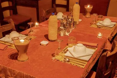 a long table with plates and wine glasses on it at Sand Fish Camp in Merzouga