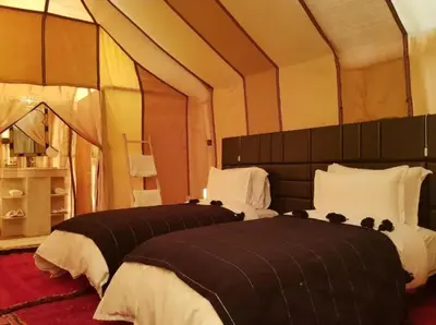 a bedroom with two beds in a tent at Sud Est Camp in Merzouga