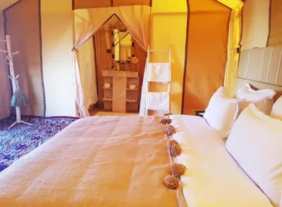 a bedroom with a large bed with a tent at Sud Est Camp in Merzouga