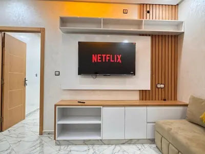 a living room with a television on a wall at Bella Nova Air-Conditioned Apartment in Azrou