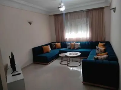 a living room with a blue couch and a table at sabri in Beni Mellal