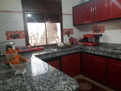 a kitchen with red cabinets and a counter top at sabri in Beni Mellal