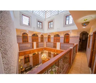 a large building with a staircase and a balcony at Riad Haddaji fez in Fès
