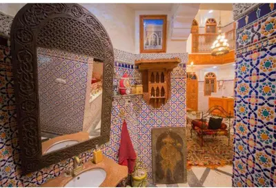 a bathroom with a mirror and a sink at Riad Haddaji fez in Fès