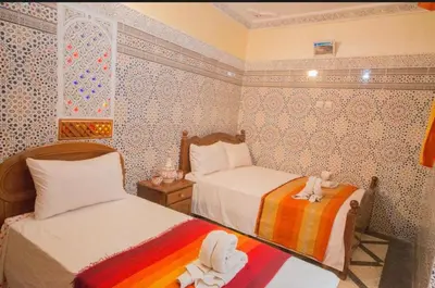 a bedroom with two beds with stuffed animals on them at Riad Haddaji fez in Fès