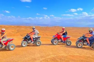 a group of people riding on atvs in the desert at la petite maison du désert in Foum Zguid