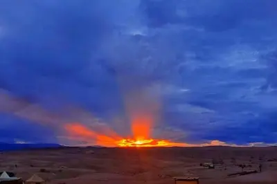 a sunset in the desert with a cloudy sky at la petite maison du désert in Foum Zguid