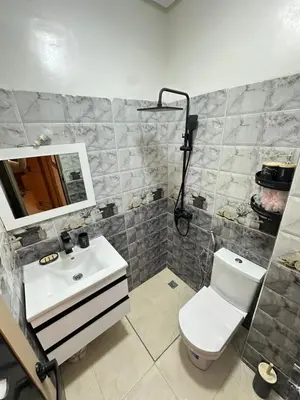a bathroom with a sink and a toilet and a mirror at Chic & Cozy Apartment for a Comfortable Stay Fes in Fès
