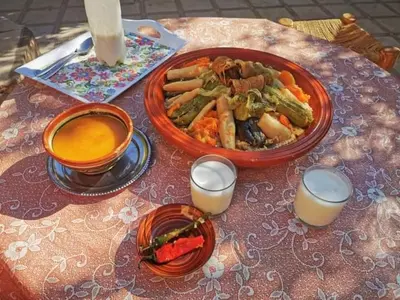a table with a plate of food and a bowl of food at Hassan's Guest House in Mhamid