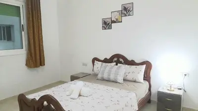 a small bedroom with a bed and a table at City escapade apartement in Fès