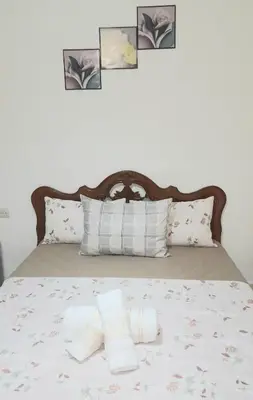 a bed with four pillows and a headboard with four pictures at City escapade apartement in Fès