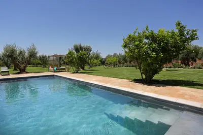 a large swimming pool in a yard with trees at Salamouni Villa ideal for family, 4-6 chambres, 8-12 personnes in Oulad Snaguia