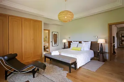 a bedroom with a bed and a chair and a chandelier at Salamouni Villa ideal for family, 4-6 chambres, 8-12 personnes in Oulad Snaguia