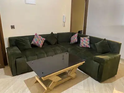 a green couch in a living room with a coffee table at Appartement calme et spacieuse in Meknès