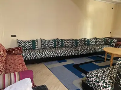 a living room with a couch and a table at Appartement calme et spacieuse in Meknès