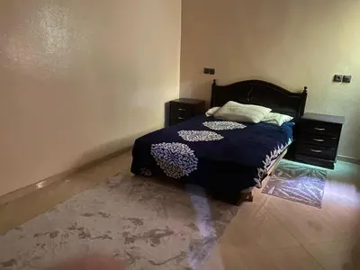 a bedroom with a bed and a dresser at Appartement calme et spacieuse in Meknès