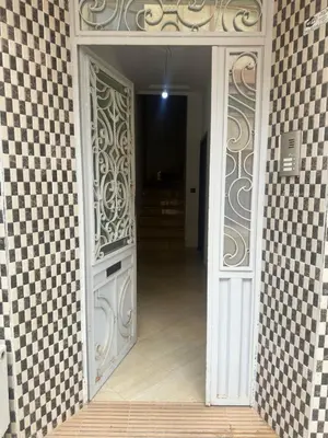 an open door to a room with a tile wall at Appartement calme et spacieuse in Meknès