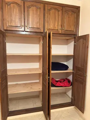 a wooden cabinet with open shelves in a room at Appartement calme et spacieuse in Meknès