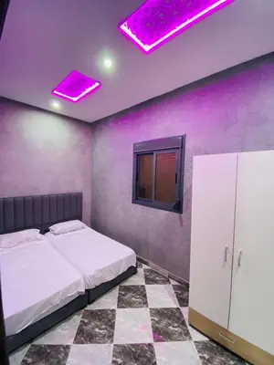 a bedroom with purple walls and a bed and purple lights at Casa Kush in Sidi Bouzguia