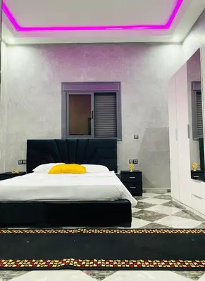 a bedroom with a large bed with a yellow pillow at Casa Kush in Sidi Bouzguia