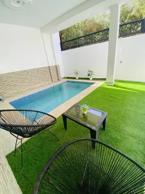 a patio with a pool and a table and a chair at Casa Kush in Sidi Bouzguia
