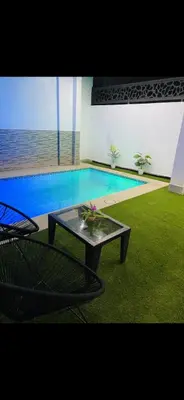 a pool with a table in front of a swimming pool at Casa Kush in Sidi Bouzguia