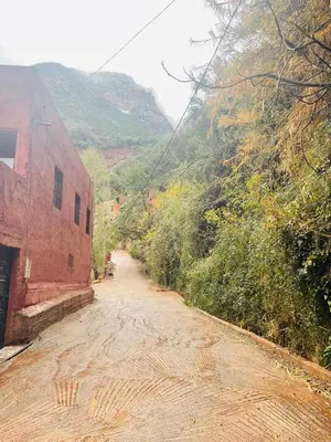 a dirt road next to a building on a mountain at Family house in Ourika