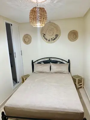 a bedroom with a bed and a chandelier at Family house in Ourika