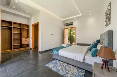 a bedroom with a large bed and a table at Red villa, pool not overlooked in Oulad Akkou