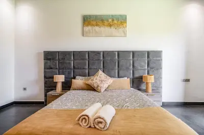 a bedroom with a large bed with two towels on it at Red villa, pool not overlooked in Oulad Akkou