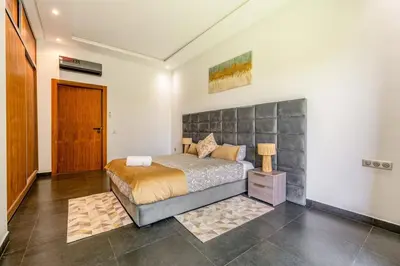 a bedroom with a bed and a wooden door at Red villa, pool not overlooked in Oulad Akkou